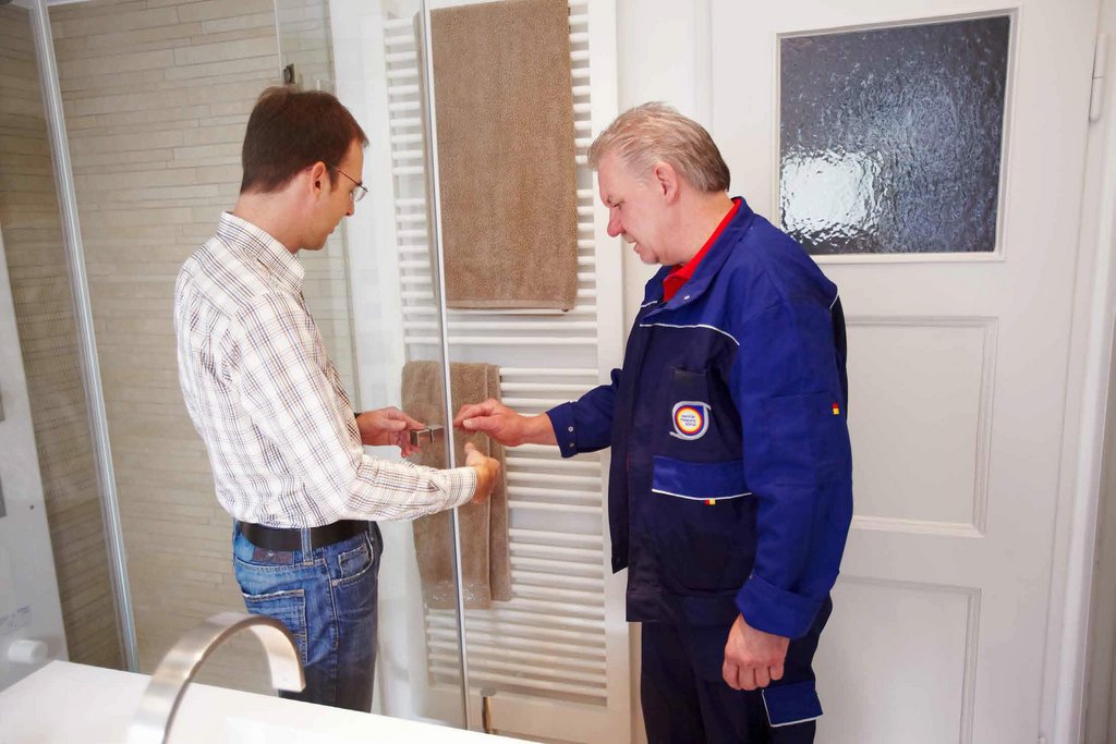 Ein Handwerker und ein Kunde geben sich die Hand